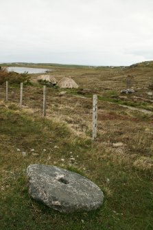 View of millstone with mill buildings in background;  Horizontal Click Mill, South Shawbost, Lewis.