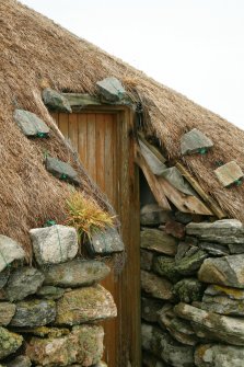 Detail of stone weights on thatch over doorway of outbuilding; Reumisgarry, North Uist.