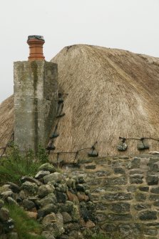 Detail of thatch and stone weights at chimney breast; probable 19th century cottage; Laimrig Ruadh, Berneray.