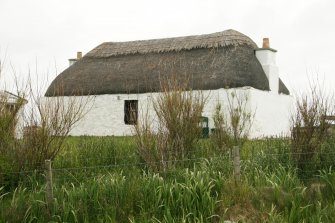 Front view of thatched cottage showing scobed ridge; 10 Uachdar, Benbecula.