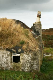 Detail of thatched roof and chimney stack showing serious deterioration; 1 Aird Cumhang, Hacklet, Benbecula.