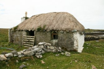 View of probable 19th century  marram thatched cottage, now unoccupied and in poor state; 11 Rhugha Sinish, South Uist.