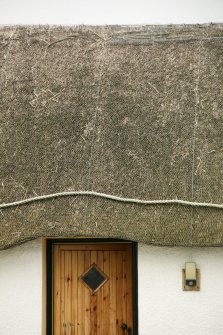 Detail of netted thatch with rope over doorway;  51 Balgarva, Eochar, South Uist.