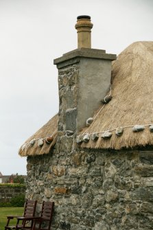Detail of weighted thatch around chimney stack;  Eochar, 96 Bualadubh, South Uist.