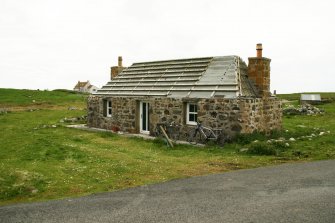View of 19th century cottage, formerly with 'muran thatch roof' now in process of re roofing; 153 Howmore, South Uist.