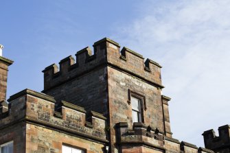 Exterior. Detail of castellations on south elevation.