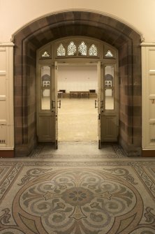 Undercroft. Passage looking through doors to main hall.