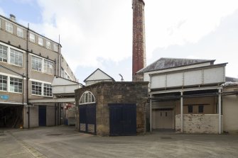 Courtyard. General view from north east of east boiler house and chimney. Access to the loading bank on the left and on the right, through the double door, access to Wet Process areas