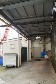Courtyard. View from north under east boiler house water tanks. Loading bank dube doors (centre)