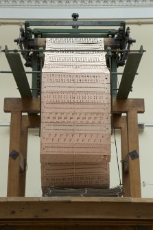 Interior. General view. Jaquard loom in gallery area. View of punch or cut cards.
