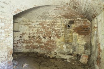 Interior of NW shell store with bricked up shell hoist on right side of facing wall.