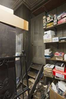 Storeroom. View of stepped access to toilet and shop fittings.