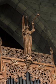 Choir, detail of carved angel on top of organ pipes
