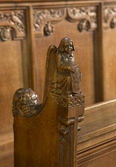 Choir, detail of carved angel with shield on choir stalls