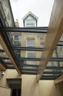 Ground floor, cafe extension, view looking through glazed roof to windows of original building