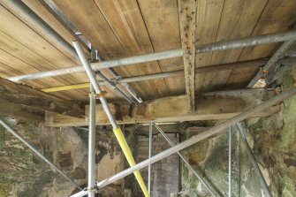 Interior. Ground floor. View of possible original joist from south west. Scaffolding installed to enable work on the building.