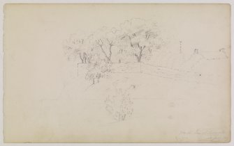 View in Lasswade of trees and a wall with distant view of the roof of a house and the church spire.
