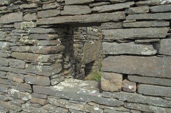 West range, north end, view looking through window on west wall to fireplace beyond