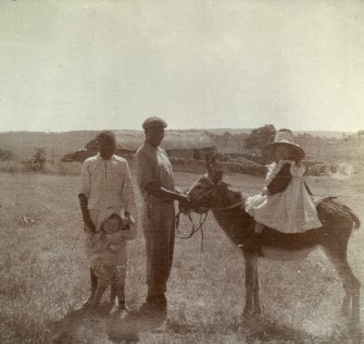 Group of two children, one on a donkey with two men.
Titled 'Glen Lorne 1907. Rhodesia; Cow kraal in distance; Walter Edmonds, Lorna Edmonds'.
PHOTOGRAPH ALBUM NO.116: D M TURNBULL
