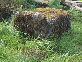 A concrete block with an asymmetrical iron loop on its summit