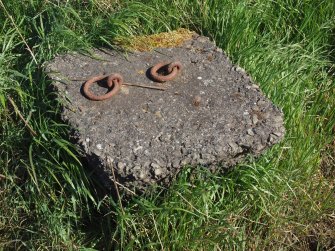 A concrete block with two iron rings