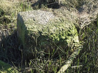 A concrete block with an asmmetrical iron loop on its summit