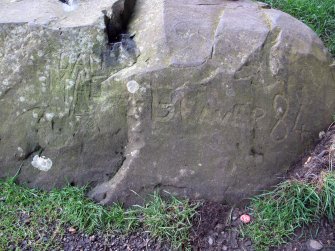 Detail view of carved graffiti that reads 'Dan Mac' and 'Beaver 84'.