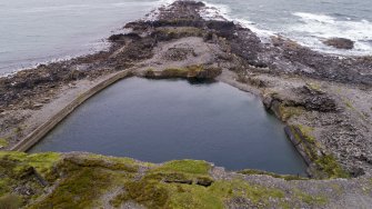 Oblique aerial view from north of Fang Quarry with some of its waste tipped into the south coastal quarries