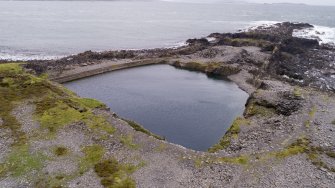 Oblique aerial view of Fang Quarry and some slate waste tipped into the south coastal quarry area. The  ridge running down the centre of the south coastal quarries is clearly shown