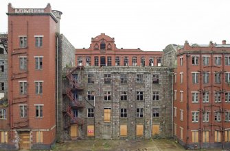 Elevated view of Old Mill (1808, centre) and later (1920s) red brick stairwell and lavatory blocks. The 1914 Red Mill is beyond.