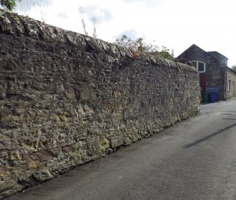 A view from the NE looking down Ashlar Lane. The boulder bearing the incised cross is build into the foot of the wall on the left.