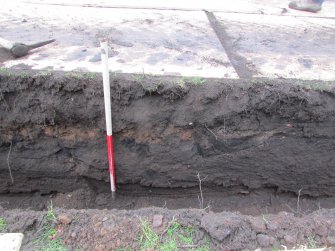 North facing section showing layer of rubble spread seperating topsoil from subsoil at western end of trench. 1.00m scale, direction S