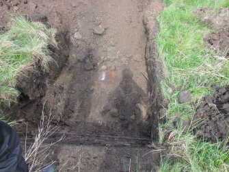 View of Trial Pit 10 topsoil stripped with shadows, direction W