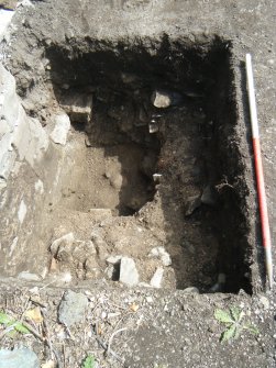 Trench 1. Mortar exposed beneath stone rubble (002) and sondage with skull fragment, direction E