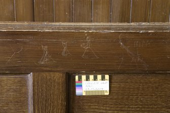 Loft. Detail of graffiti on pew back (with scale.)