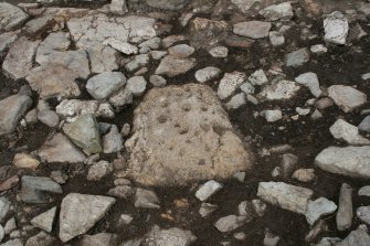 Cup and ring marked stone in Norse House during excavation
