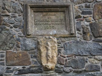 Rodel church. Exterior. Plaque commemorating the restoration of the church by Catherine Herbert, Countess of Dunmore, in 1873. Below this, an architectural fragment of medieval date showing a crucifixtion scene.