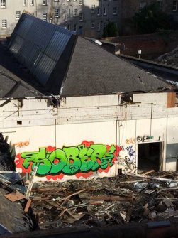 View of piece on interior wall of partially demolished factory.