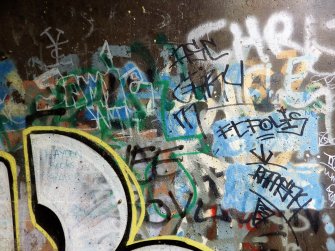 A view of some of the graffiti on the concrete abutments of the footbridge.