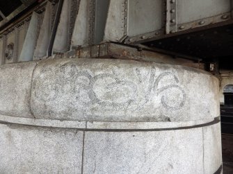 Close-up view of partly erased graffiti on a pier.