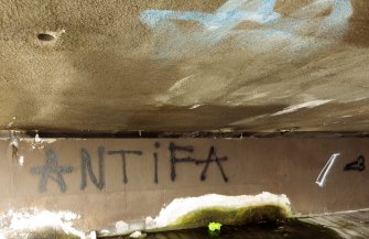 View of graffiti written on the underside of the bridge.