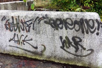Graffiti on concrete block on top edge of one of the stairways leading down into graving dock number 3 from its south side.