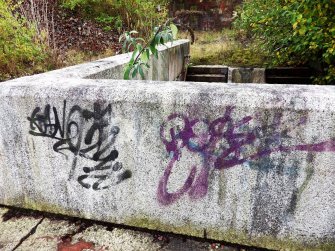 Graffiti on concrete block on top edge of one of the stairways leading down into graving dock number 3 from its south side.