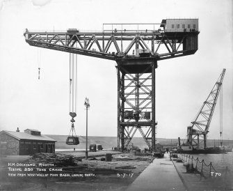 View of testing of 250 tons crane at H M Dockyard, Rosyth, from west wall of main basin looking north.