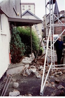 The step at the front of the building partially dismantled to allow access for machine.