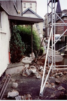 The step at the front of the building partially dismantled to allow access for machine.