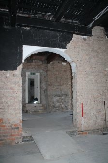 Historic building recording, Room 0/4, Detail of round headed doorway in brick partition wall from E, Former United Presbyterian Church, 17-21 Blackfriars Street, Edinburgh