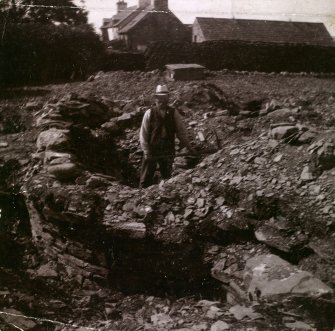 Photograph man standing in interior of Kilminster Broch (mound).