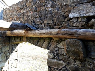 View from the interior of the cart-shed of the lateral end-joist that supported the SE ends of the longitudinal joists of the timber first floor.