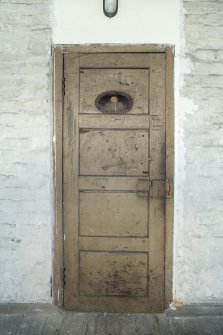 Cell 2. View of door with pencil drawn graffiti. 
